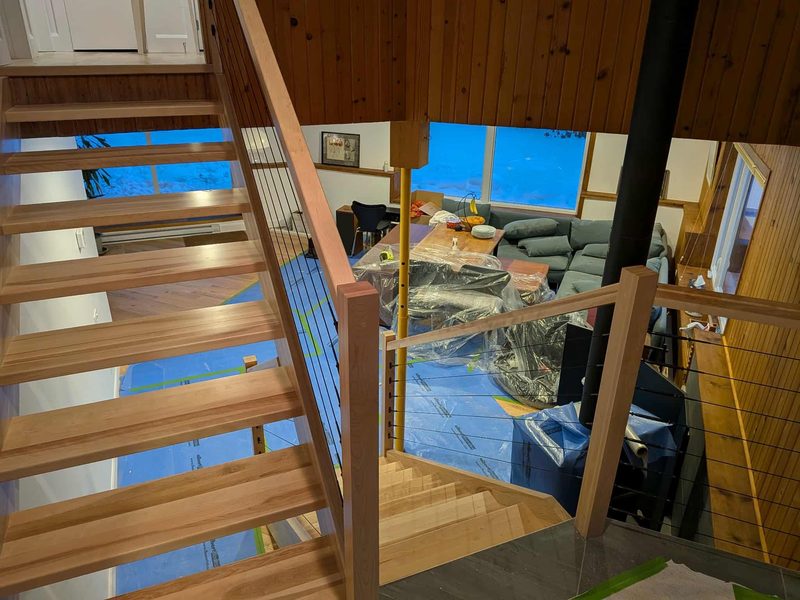 Escalier flottant à deux volées avec garde-corps à câbles d'acier, pendant l'installation