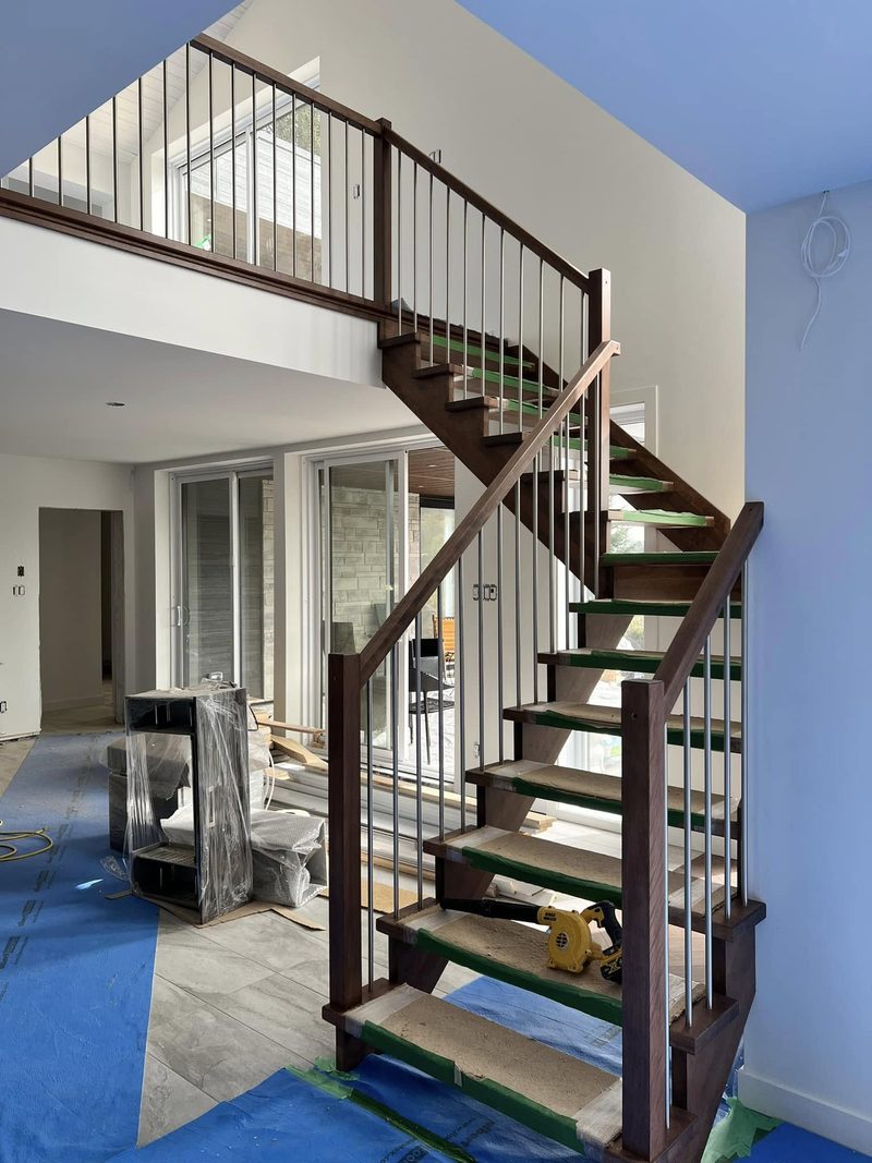 Escalier flottant tournant en bois teint avec barreaux noirs