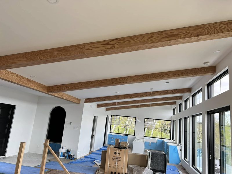 Poutres décoratives en chêne au plafond d'une pièce vitrée