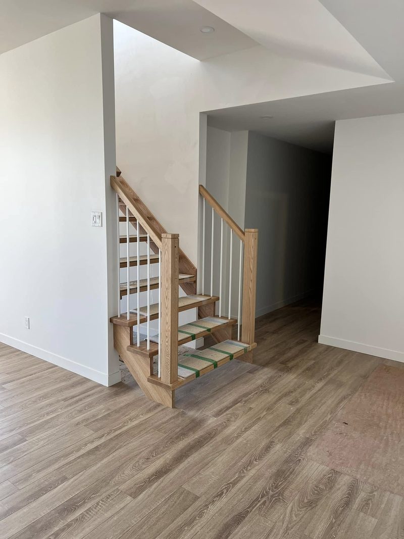 Court escalier en bois naturel avec garde-corps à barreaux