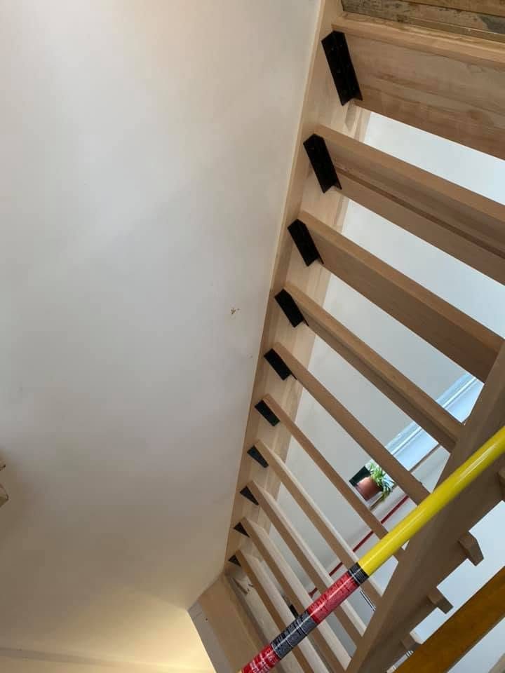 Dessous d'un escalier flottant en bois clair