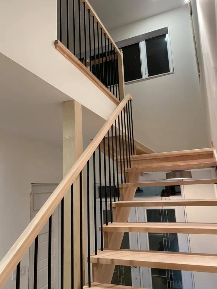 Escalier flottant en merisier avec barreaux noirs