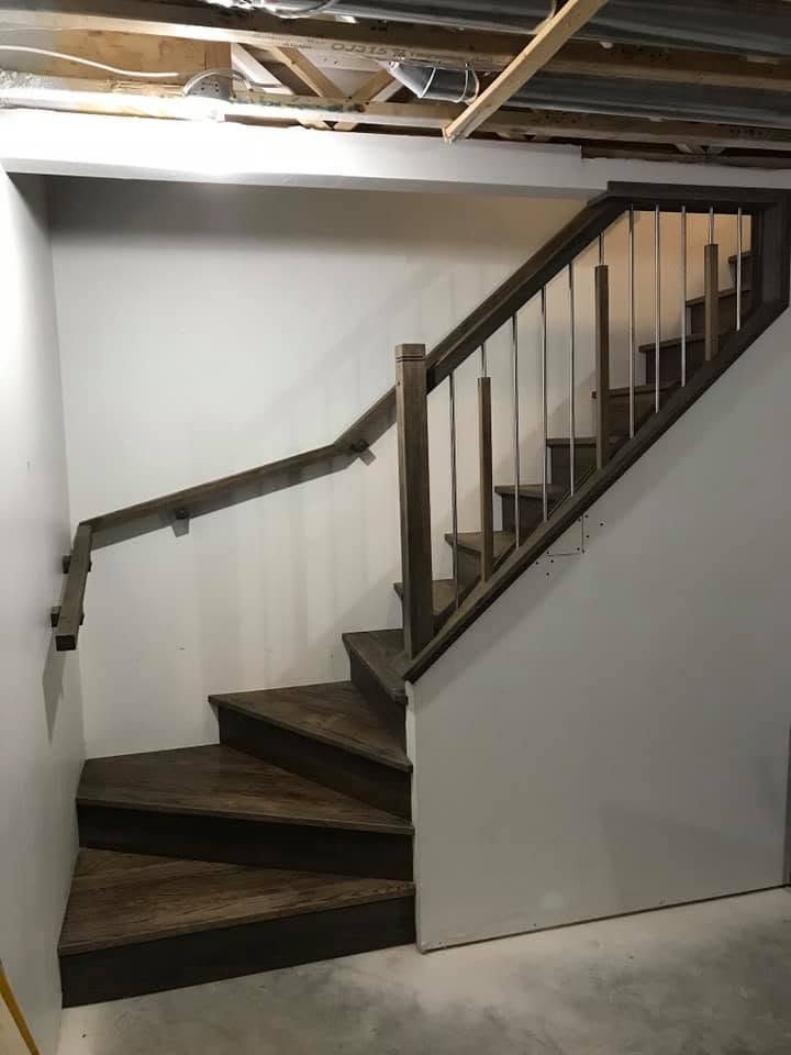 Escalier tournant en bois foncé menant au sous-sol