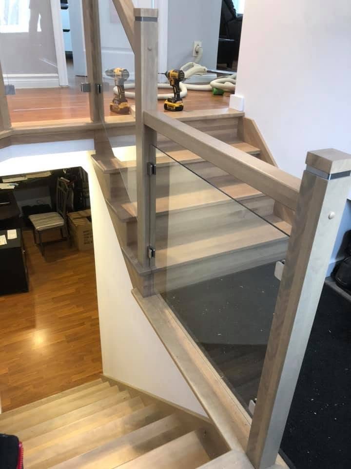 Garde-corps de verre et bois clair au-dessus d'un escalier